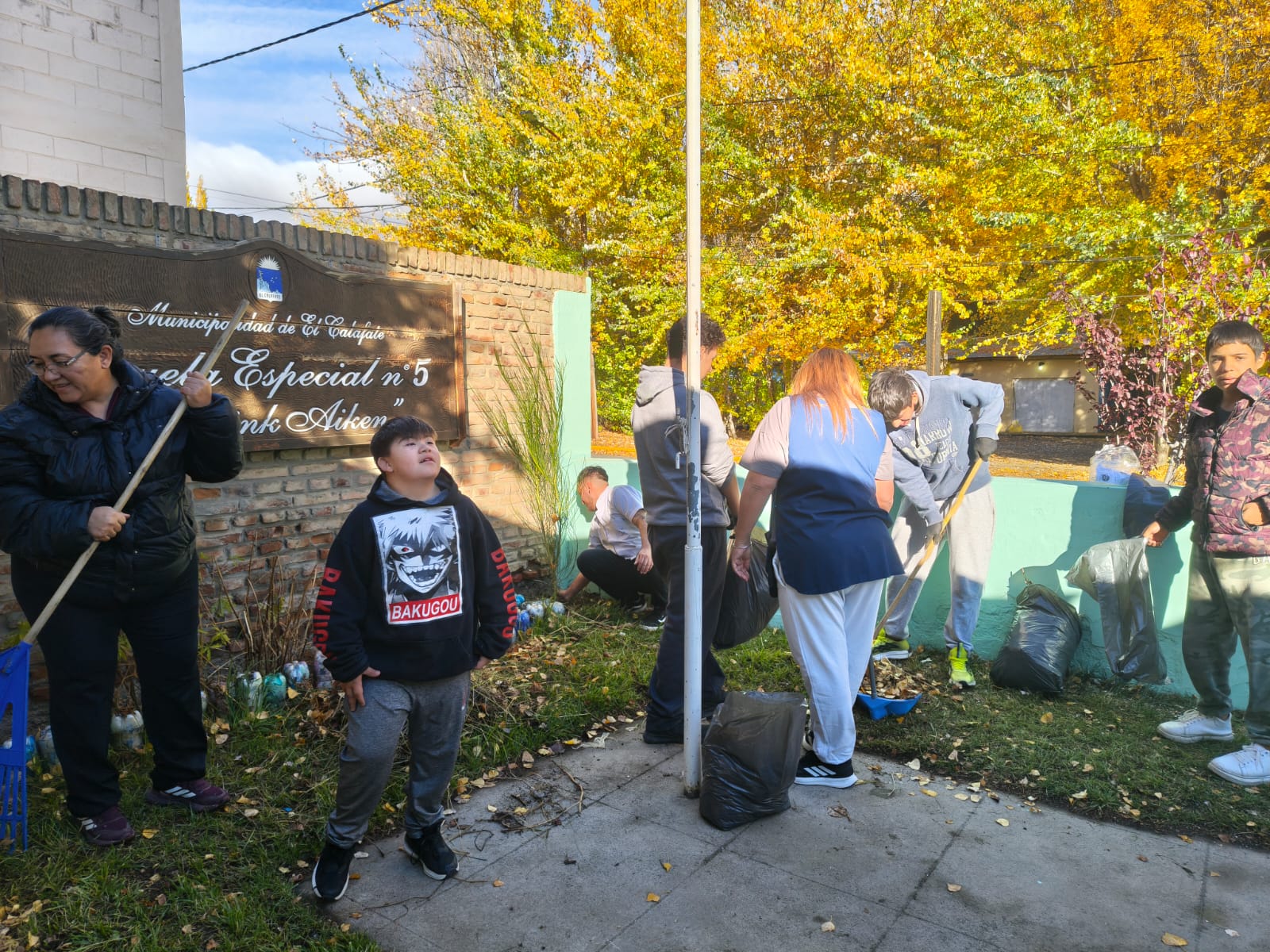 Estudiantes y docentes de la Escuela Especial N°5 limpiando el patio y el jardín de la escuela